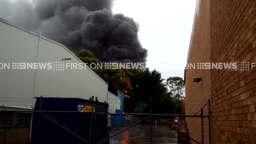 Thick smoke gushes from the building. (9NEWS)
