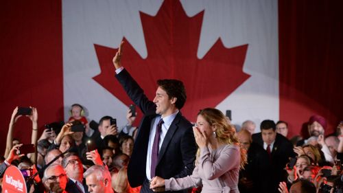 Liberal leader Justin Trudeau makes his way to the stage with his wife, Sophie, after winning the election. (AAP)