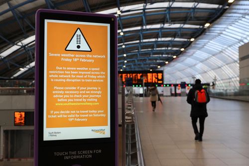 Une personne passe devant un panneau à la gare de Waterloo, alors qu'un avertissement météorologique rouge a été émis en raison de la tempête Eunice, à Londres, en Grande-Bretagne, le 18 février 2022. 