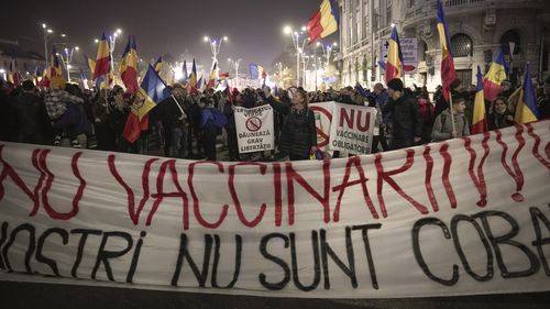 Oamenii țin un banner mare pe care scrie "Nu vaccinării - copiii noștri nu sunt cobaii tăi" În timpul unui protest împotriva vaccinărilor în București, România. 