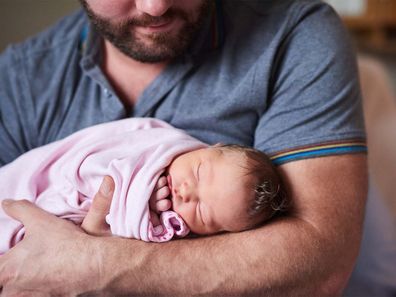 Father holding newborn baby girl