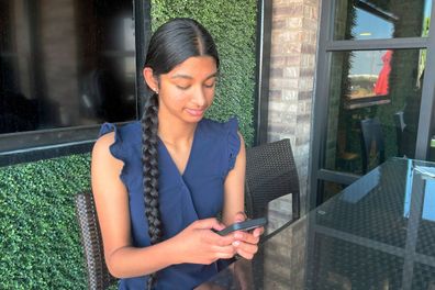 Shreya Nallamothu looks at her phone in May 2023 in Bloomington, Illinois. The teenager was instrumental in persuading Illinois lawmakers to pass a law creating protections for child social media influencers.