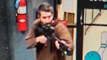 An unidentified gunman points a gun while entering Sparetime Recreation in Lewiston, Maine.