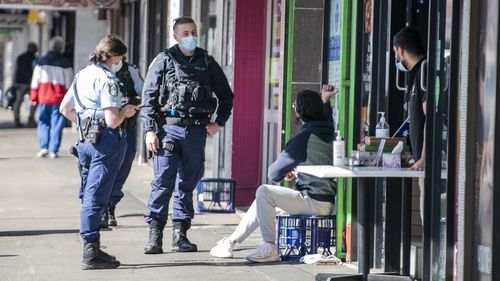 Police speaking to a man not wearing a mask, Merrylands Road, Merrylands on August 18.