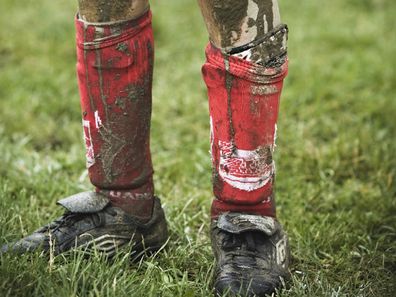 child covered in mud after soccer game legs only