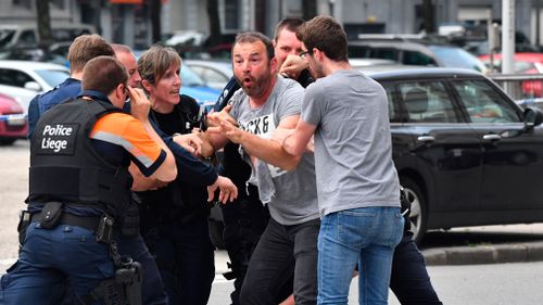A man is visibly upset as he approaches the scene. Picture: AP