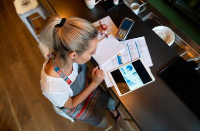 Portrait of a business manager doing the books at a bar using a tablet computer