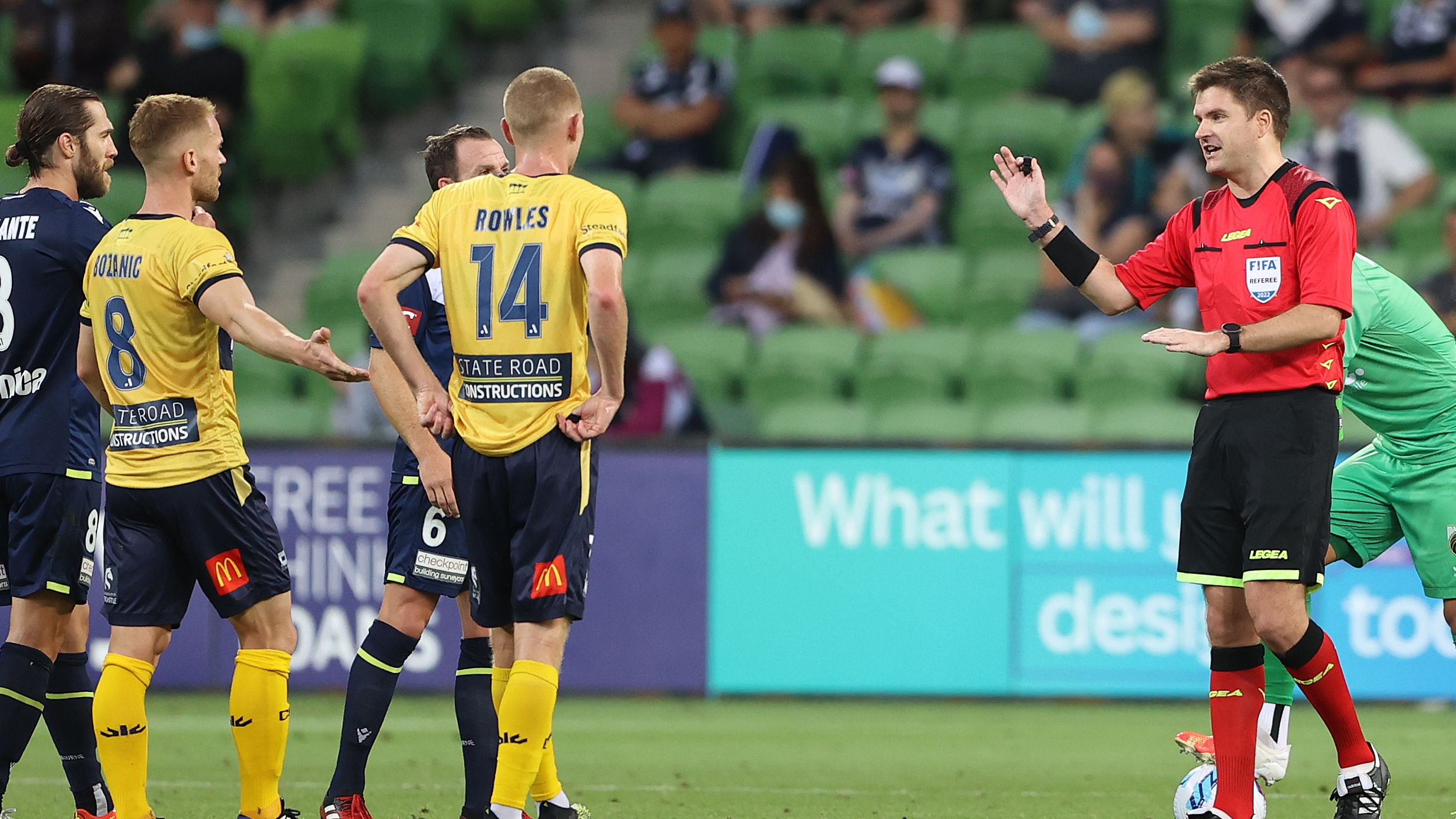 Referee Adam Kersey speaks to players as he awaits a VAR decision during the match between Melbourne Victory and Central Coast Mariners at AAMI Park.