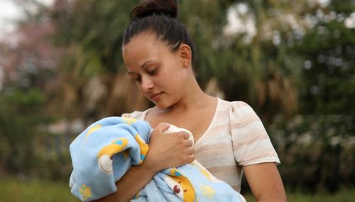 Honduran migrant Genesis Martinez, 18, poses for a picture holding her two-month-old son Cesar. (AP)