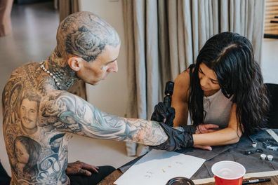 Kourtney Kardashian gives Travis Barker a tattoo.