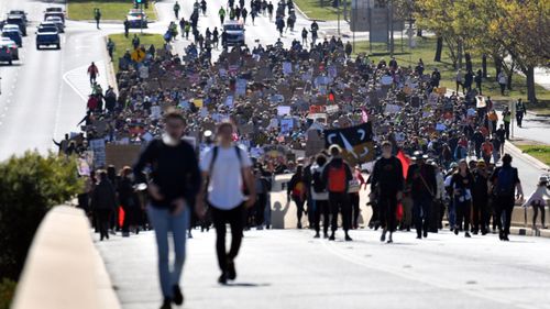 Black Lives Matter protesters march in front of Parliament House in Canberra.