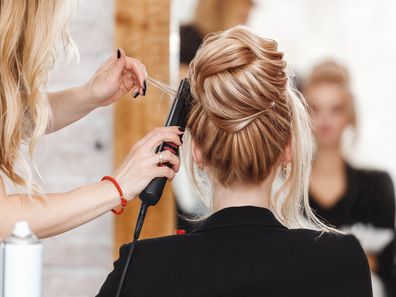 A woman having her hair cut by a hairdresser