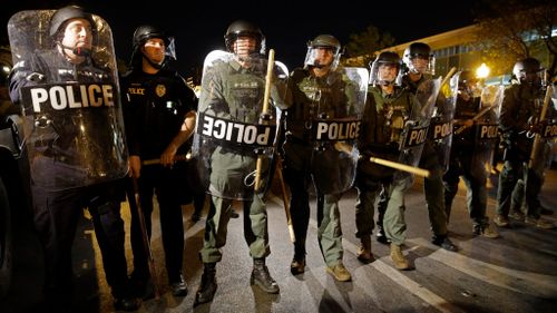 Police stand in formation as a curfew approaches in Baltimore, on April 29, 2015. (AAP)