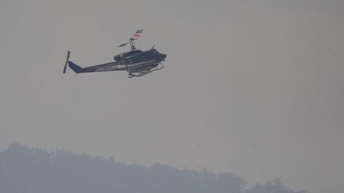 A Tasmanian Fire Service helicopter pictured on patrol, at Huonville, near Hobart yesterday.