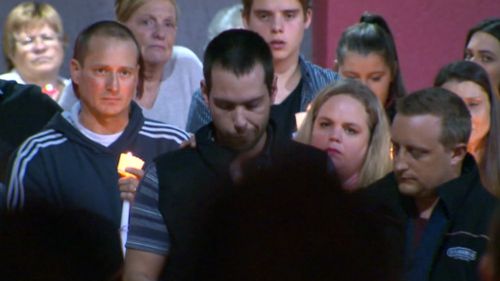 Mourners held candles at the Carrum Downs shopping centre car park.