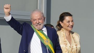 President Luiz Inacio Lula da Silva, left, waves to supporters as he holds hands with his wife Rosangela Silva at the Planalto Palace in Brasilia, Brazil, Sunday, Jan. 1, 2023. (AP Photo/Andre Penner)
