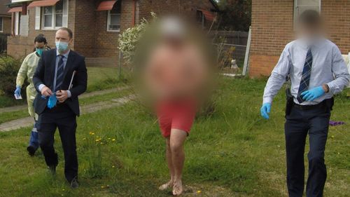 Detectives take a man into custody after searching a home in Wentworthville, in Sydney's west.