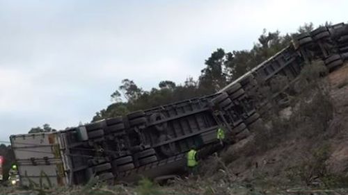 The truck reportedly crossed the highway before colliding with a car and rolling.