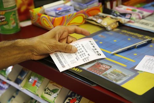 A customer buys a Powerball ticket, Thursday, June 8, 2017, in Chicago. The Powerball jackpot has grown up to $435 million, after more than two months without a winner. The jackpot for Saturday night's drawing would tie for the nation's 10th largest lottery prize. (AP Photo/G-Jun Yam)