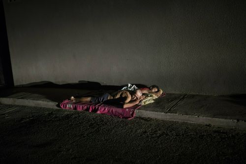 People sleep on the sidewalk to escape from the heat, due to the lack of electricity in their homes that does not allow them to run their air conditioners and fans, during a blackout in Maracaibo, Venezuela. (AP Photo/Rodrigo Abd)