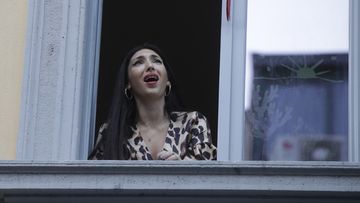 Opera singer Laura Baldassari leans out of her window to sing as the country tired to boost morale.