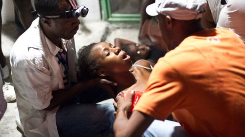 A woman faints in the arms of a medic in an emergency clinic in Port-au-Prince, Haiti on January 12, 2010 after a 7.0 earthquake rocked across the island nation. (Getty)