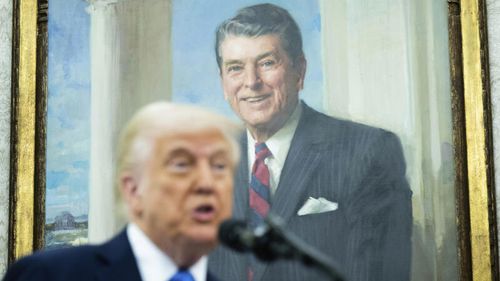 With a painting of former President Ronald Reagan behind him, President Donald Trump speaks during a swearing in ceremony for Alina Habba as interim US Attorney General for New Jersey, in the Oval Office of the White House in Washington