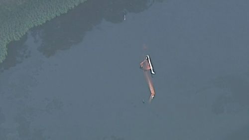 New pictures show the water bombing helicopter half submerged in the dam.