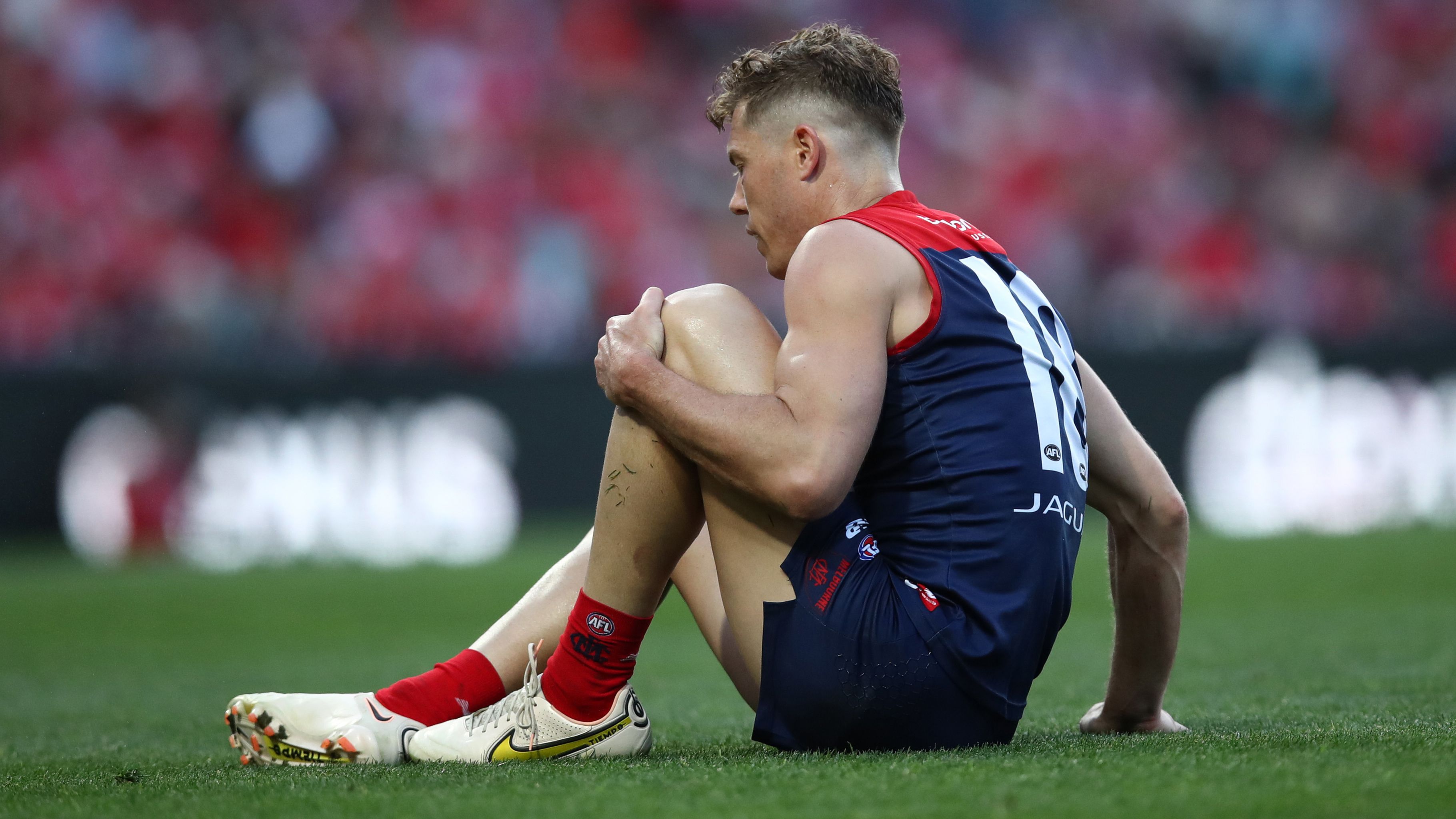 SYDNEY, AUSTRALIA - AUGUST 27: Jake Melksham of the Demons holds his knee during the round 24 AFL match between Sydney Swans and Melbourne Demons at Sydney Cricket Ground on August 27, 2023 in Sydney, Australia. (Photo by Jason McCawley/AFL Photos/via Getty Images )