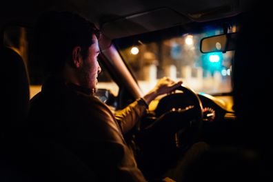 Man driving in car at night