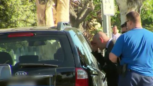 Police peer into the Kia yesterday afternoon after the boy was rushed to hospital. (9NEWS)