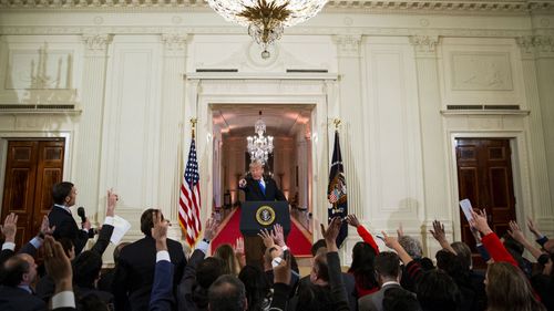 Trump takes questions from reporters in the East Room of the White House. 