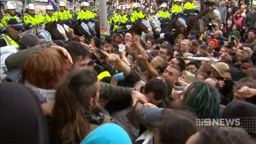 Police were caught in the middle of the angry protests by the two groups. (9NEWS)