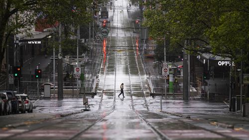 A lone person is seen crossing Bourke Street Mall  in Melbourne.
