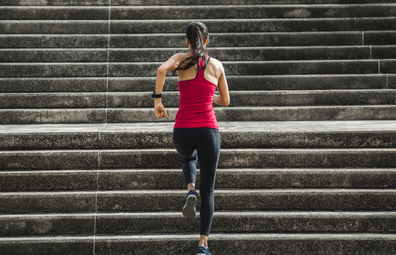 Woman exercising, running up a flight of stairs