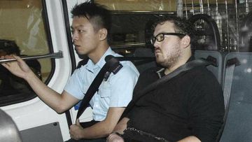 Rurik George Caton Jutting, right, is escorted by a police officer in an police van before appearing in a court in Hong Kong. (AP)