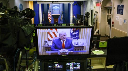 President Donald Trump on a television monitor in an empty press conference room at the White House in Washington.