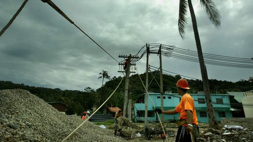 Thai constuction workers reinstall powerlines in the tsunami affected area of Phi Phi island. The island was one of the worst hit areas in Thailand by the 2004 Boxing Day tsunami.