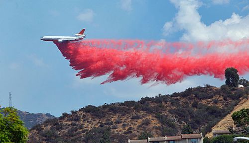 A firefighting aircraft douses the fires with anti-accelerant. (Associated Press).