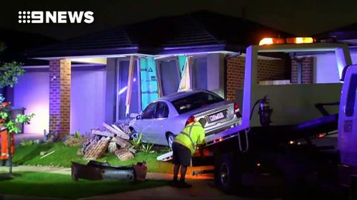 Workers attempt to remove the car. (9NEWS)