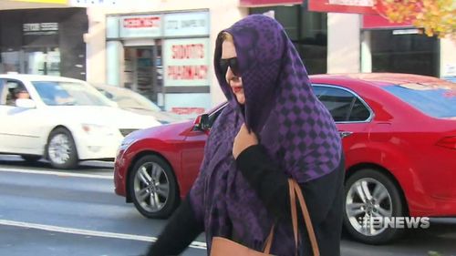 The Yagoona woman, whose name has been suppressed, covered her head with a purple scarf in attempt to avoid film crews as she arrived at court today. Picture: 9NEWS