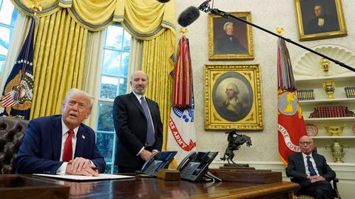 Rupert Murdoch siede nello Studio Ovale mentre Donald Trump parla.