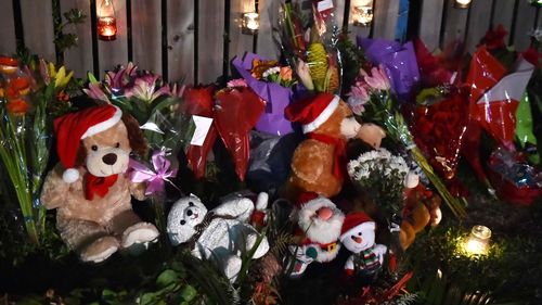 Community members have paid tribute to the children by laying flowers and soft toys on the curb across the road from the house. (Getty)