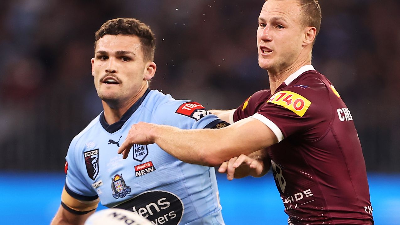 Nathan Cleary of the Blues kicks next to Daly Cherry-Evans of the Maroons during the 2022 Origin series.