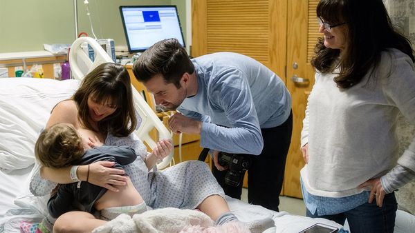 Birth day: labouring Mum Kate Neal breastfeeds her toddler daughter in between contractions. Image: Maegan Dougherty Photography