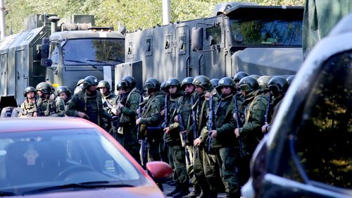 Military forces block the road to the site of attack at a vocational school in Kerch in Crimea, Russia.