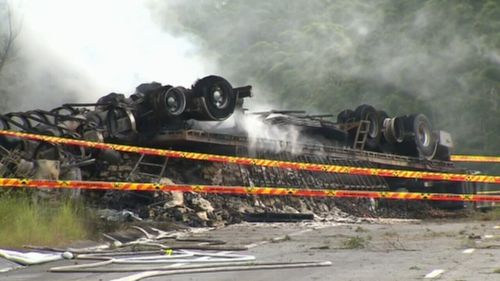 The truck overturned and burst into flames, with the driver trapped inside. (9NEWS)
