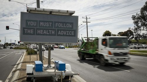 MELBOURNE, AUSTRALIA - OCTOBER 09: Traffic signs display COVID information on Sydney Road in Faulkner on October 09, 2021 in Melbourne, Australia.  Victoria has recorded 1,965 new COVID-19 cases and five deaths in the last 24 hours. It is the highest daily case figure recorded so far. Lockdown restrictions remain in place across metropolitan Melbourne and regional Victoria as new COVID-19 cases continue to emerge across the state. The state government is urging all Victorians to access the COVID