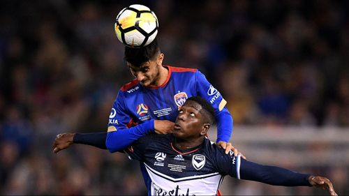 Johnny Koutroumbis of the Jets competes to head the ball with Leroy George of Victory. (AAP)