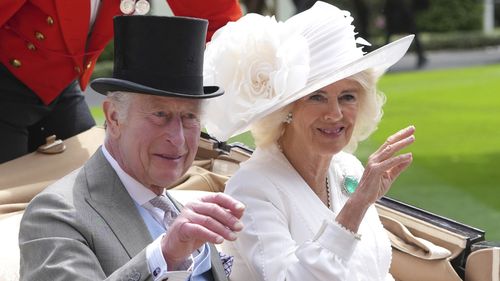 Britain's King Charles III and Queen Camilla wave to the crowds as they arrive by carriage in the parade ring on the third day of the Royal Ascot, horse race meeting, traditional known as Ladies Day, at Ascot, England, Thursday, June 20, 2024. (AP Photo/Kin Cheung)